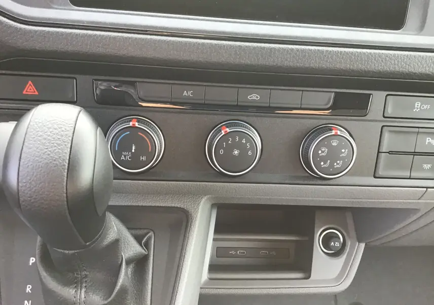 Gros plan sur la console centrale du Volkswagen Crafter blanc 2024, montrant la boîte auto et les commandes de climatisation.