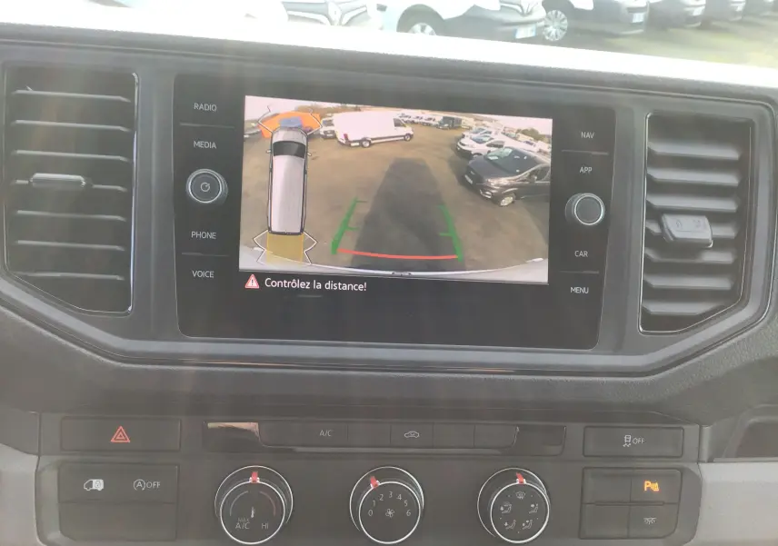 Écran central du Volkswagen Crafter 2024 montrant la caméra de recul avec vue arrière et lignes de guidage colorées.