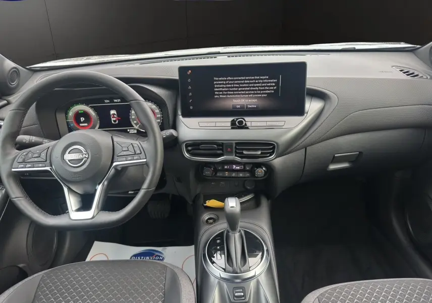 Vue intérieure du tableau de bord et volant cuir noir du Nissan Juke Full Hybrid 2025 avec écran tactile central.