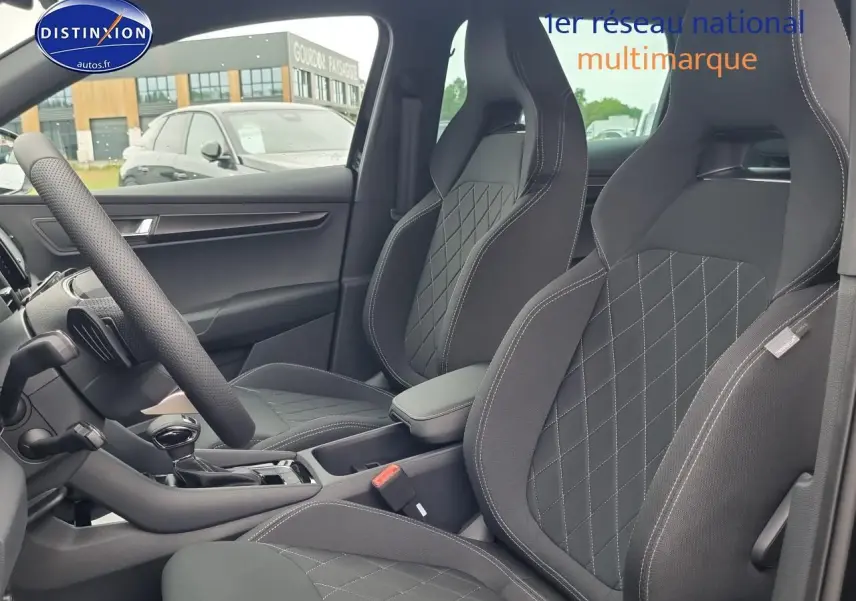 Vue intérieure côté gauche du Skoda Karoq noir 2025, mettant en valeur les sièges sport avec surpiqûres croisées et accoudoir central.