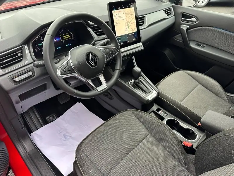 Vue intérieure côté conducteur du Renault Captur 2025 Rouge Flamme, avec tableau de bord numérique et écran tactile vertical.