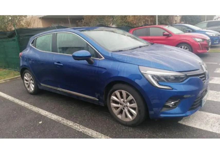 Renault Clio 2021 Bleu Iron vue de profil côté gauche, garée sur un parking extérieur par temps humide.