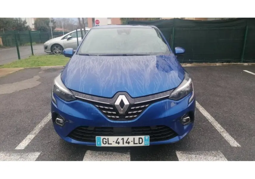 Vue avant d'une Renault Clio 1.0 Tce Intens 2021 en bleu Iron avec logo Renault et phares allumés.