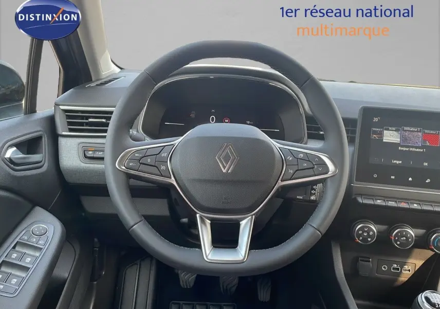 Vue intérieure centrée sur le volant cuir noir de la Renault Clio 2025 avec tableau de bord digital et écran tactile.