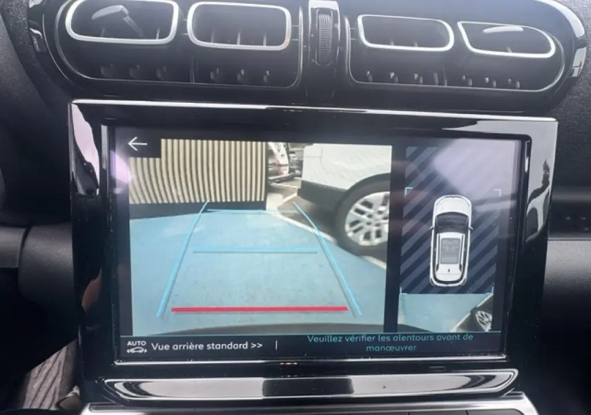 Écran tactile intérieur montrant la caméra de recul et l’aide au stationnement du Citroën C3 Aircross gris acier.