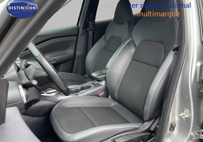 Vue intérieure côté conducteur du Nissan Juke Hybrid 143ch Business 2023 avec sièges en cuir gris et tissu noir.