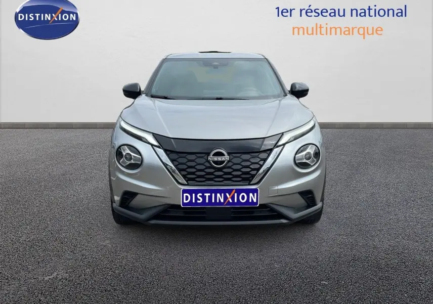 Vue frontale d'un Nissan Juke Hybrid 143ch Business gris perle métal avec calandre noire et phares ronds distinctifs.