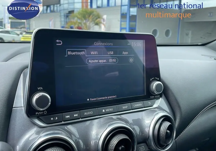 Écran tactile central avec options Bluetooth, WiFi et USB sur tableau de bord gris perle métal d'un Nissan Juke Hybrid 2023.