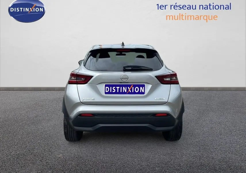 Vue arrière d'un Nissan Juke Hybrid gris perle métal, mettant en valeur ses feux LED et son design compact.