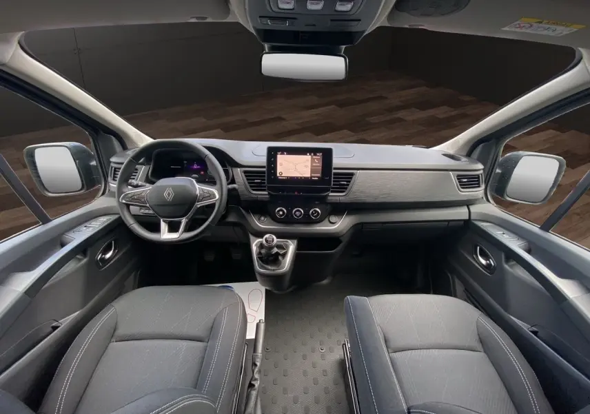 Vue intérieure avant du Renault Trafic cabine approfondie 2025, tableau de bord moderne avec écran tactile et sièges noirs.