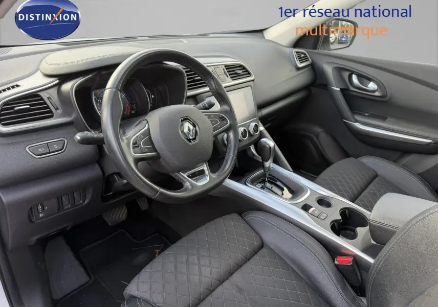 Intérieur du Renault Kadjar 2019, vue côté conducteur, volant cuir, console centrale avec boîte auto et sièges tissu noir matelassé.