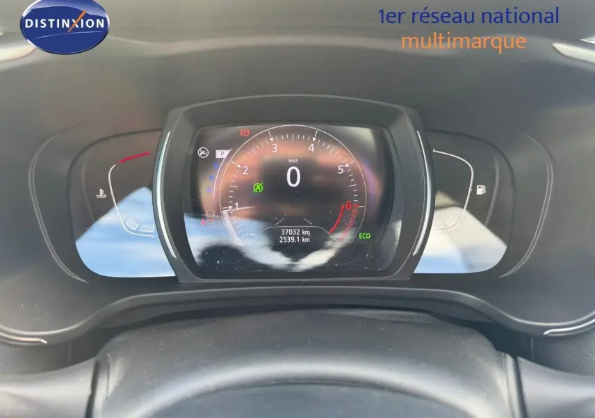Vue rapprochée du tableau de bord numérique du Renault Kadjar blanc nacré, affichant le compteur et les voyants.