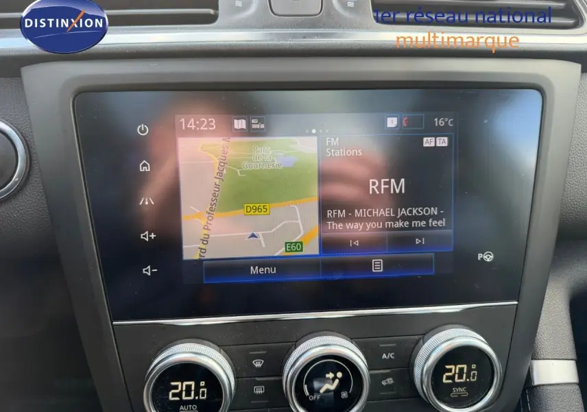 Vue rapprochée de l’écran tactile central et de la console de climatisation du Renault Kadjar blanc nacré, affichant la navigation et la radio.