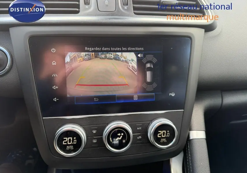 Vue rapprochée de l’écran multimédia et des commandes de climatisation du Renault Kadjar blanc nacré, affichant la caméra de recul.