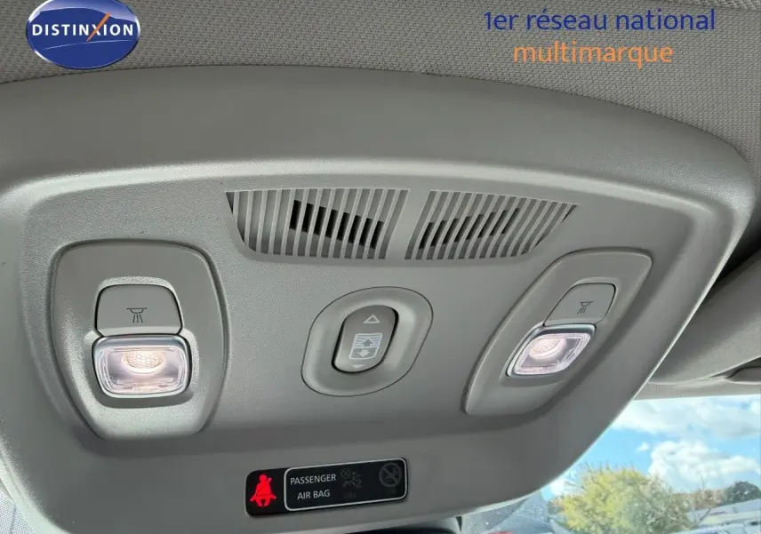 Plafonnier intérieur avec éclairages de lecture allumés et commande d'ouverture de toit ouvrant dans un Renault Kadjar blanc nacré.