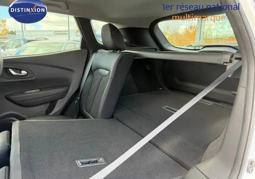 Vue intérieure arrière droite du Renault Kadjar blanc nacré, siège rabattable et espace de coffre étendu.