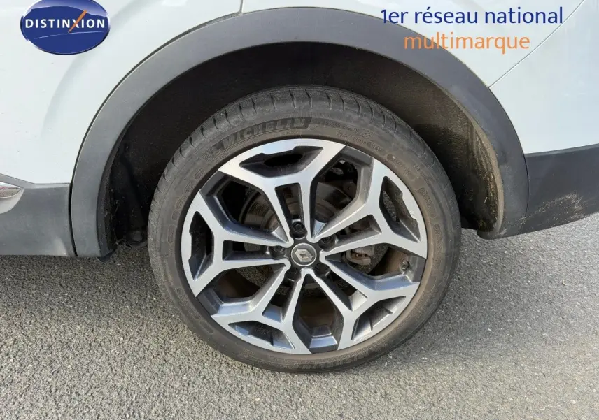 Gros plan sur la roue avant droite du Renault Kadjar blanc nacré avec jante alliage 19 pouces bicolore.