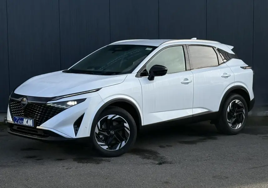 Nissan Qashqai blanc nacré en 3/4 avant droit, avec jantes alliage noires et toit contrasté noir.