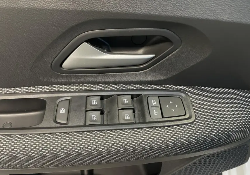 Détail de la commande des lève-vitres et rétroviseurs sur la porte avant gauche d'une Dacia Sandero Stepway blanc glacier.