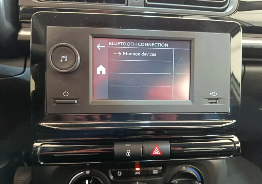 Gros plan sur l’écran tactile central et la console noire brillante du tableau de bord d’une Citroën C3 blanche de 2021.