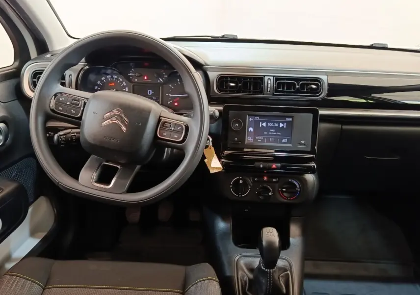 Vue intérieure avant du tableau de bord de la Citroën C3 blanche, volant multifonctions et écran tactile central visible.