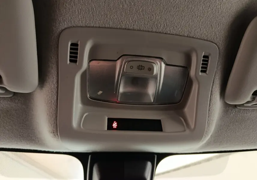 Gros plan sur le plafonnier intérieur avec éclairage et témoin de ceinture allumé dans une Citroën C3 blanche.