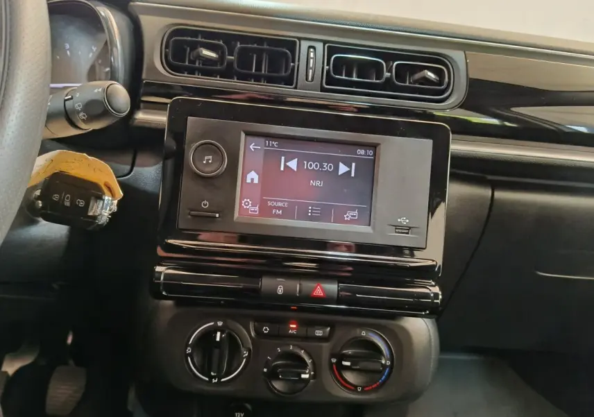 Vue rapprochée de l’intérieur de la Citroën C3 2021, tableau de bord avec écran tactile et commandes de climatisation.
