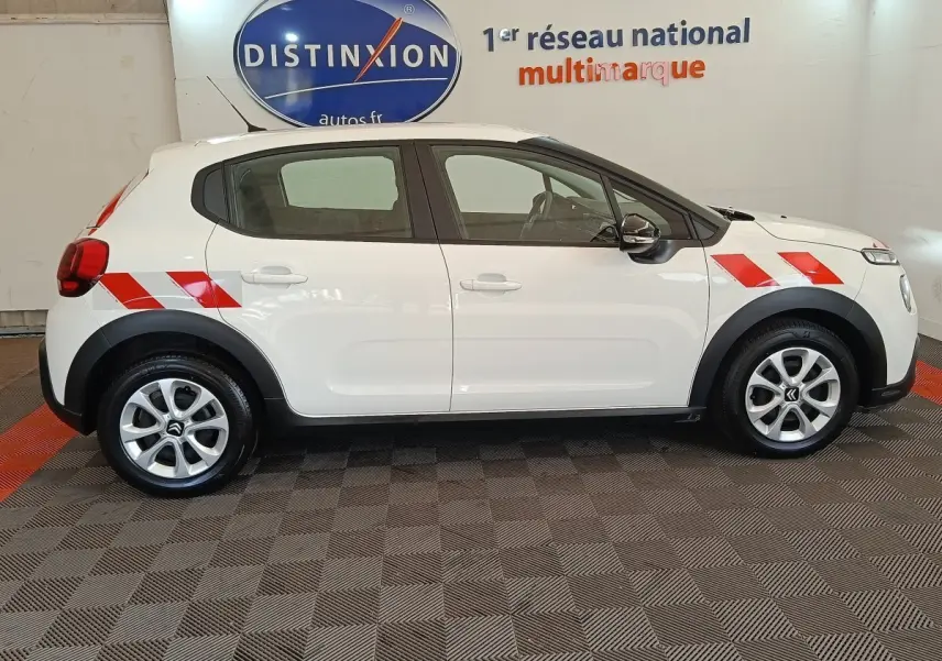 Profil côté gauche d'une Citroën C3 blanche 2021 avec bandes rouges diagonales sur ailes avant et arrière.