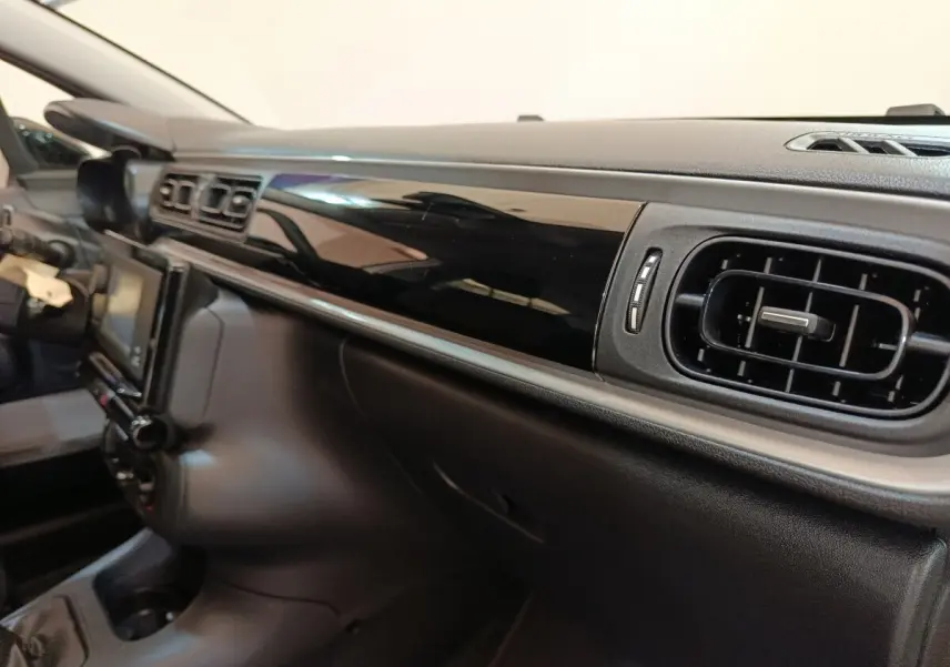 Vue intérieure du tableau de bord noir brillant côté passager de la Citroën C3 BlueHDi 100 S&S BVM Feel 2021.