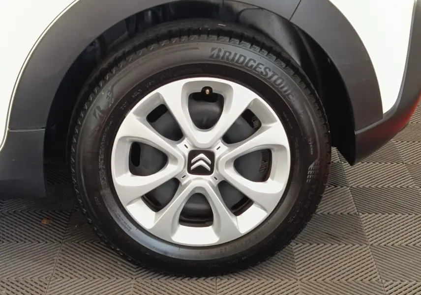 Gros plan sur la roue avant droite blanche d'une Citroën C3 2021 avec jante en alliage et logo Citroën central.