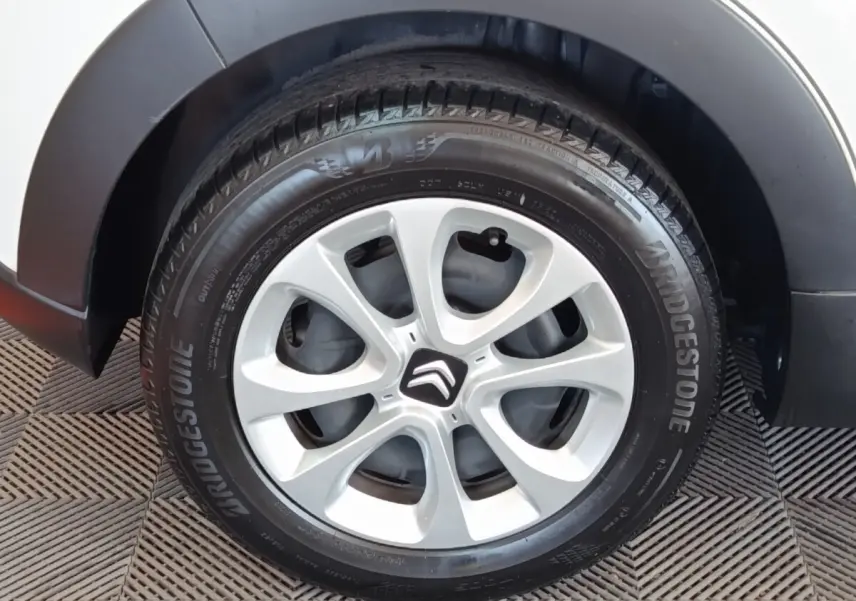 Gros plan sur la roue avant droite blanche d'une Citroën C3 avec jante alliage et pneu Bridgestone.