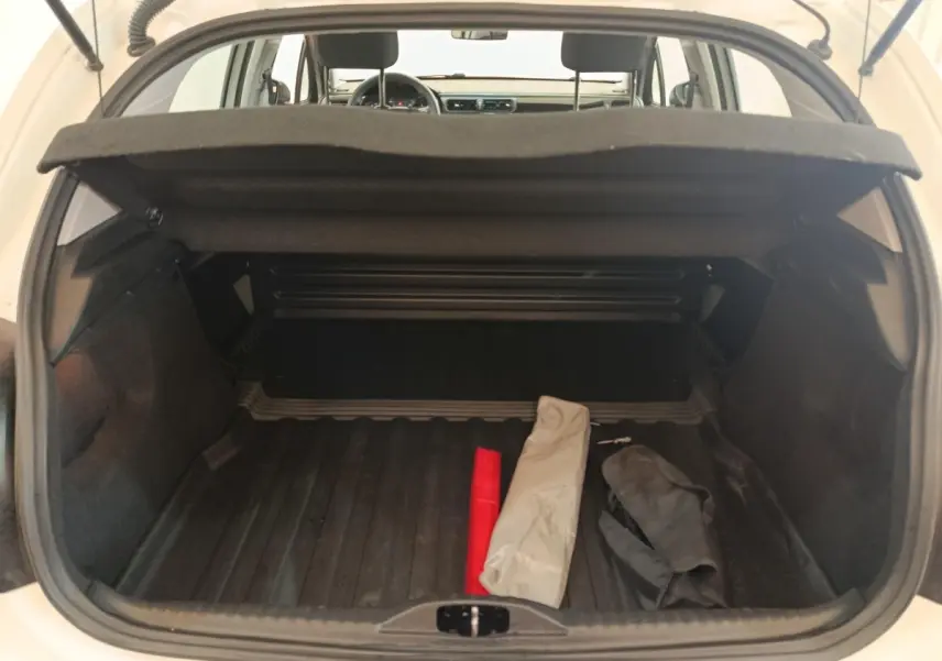 Vue arrière du coffre ouvert d'une Citroën C3 blanche 2021, montrant un espace de rangement avec objets posés.