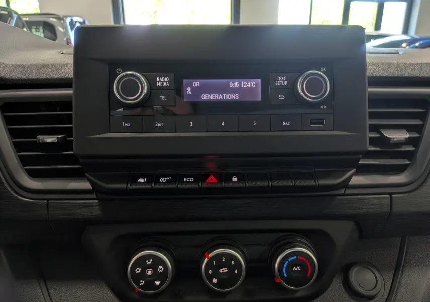 Tableau de bord du Renault Trafic Fourgon 2024, vue frontale centrée sur la console radio et les commandes de climatisation.