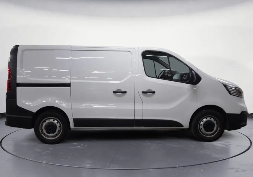 Profil droit du Renault Trafic Fourgon blanc minéral 2024, avec portes latérales et jantes acier noires.