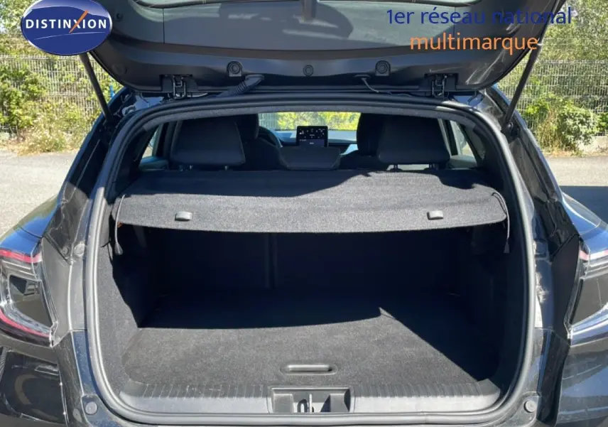 Coffre ouvert en vue arrière d’un Renault Captur noir étoile métal, montrant l’espace de chargement et la tablette arrière.