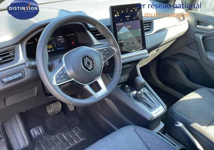 Vue intérieure côté conducteur du Renault Captur E-Tech noir étoile métal 2025, avec volant cuir multifonction et écran tactile vertical.