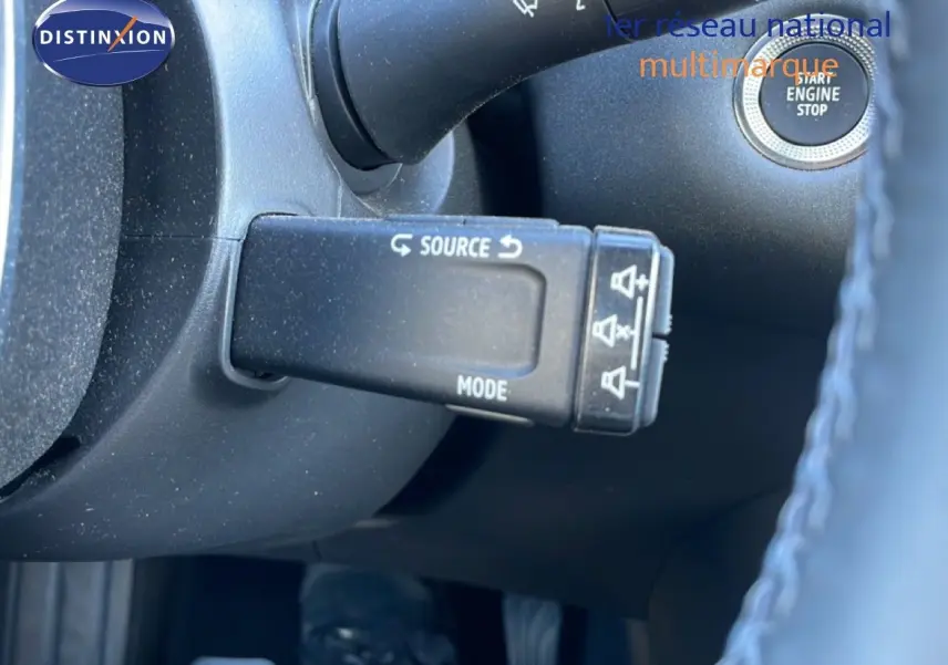 Gros plan sur la commande au volant du Renault Captur noir étoile métal, mettant en valeur le bouton source et mode.
