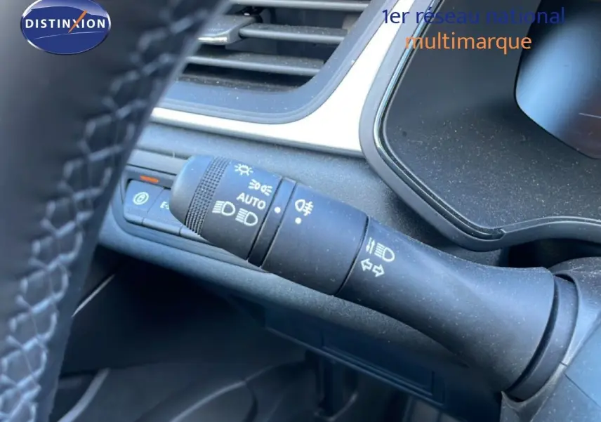 Gros plan sur la commande des feux et clignotants à gauche du volant du Renault Captur noir étoile métal, intérieur moderne.