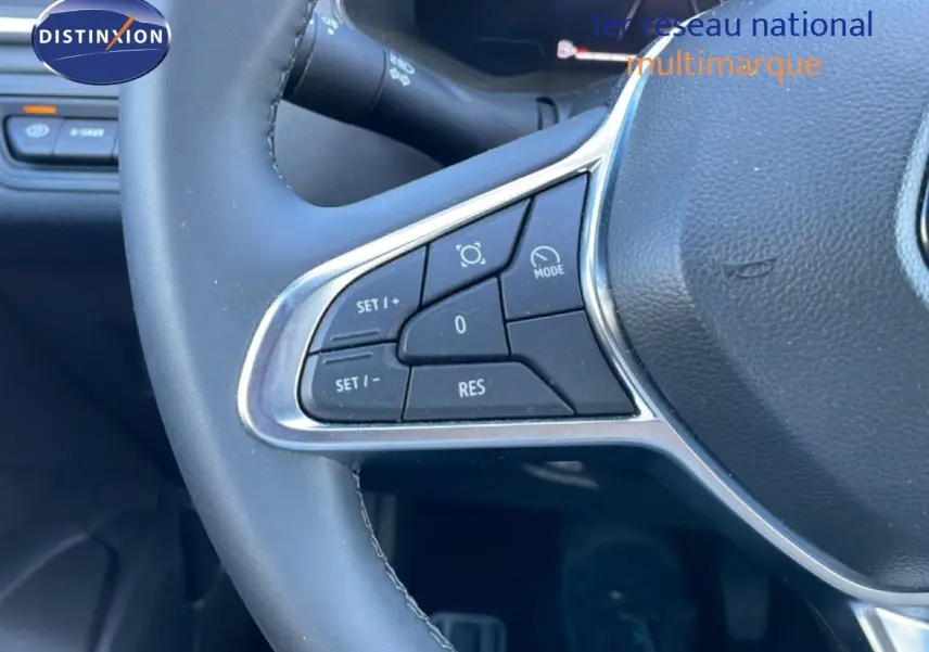 Gros plan sur les commandes au volant côté gauche du Renault Captur noir étoile métal, version hybride 2025.