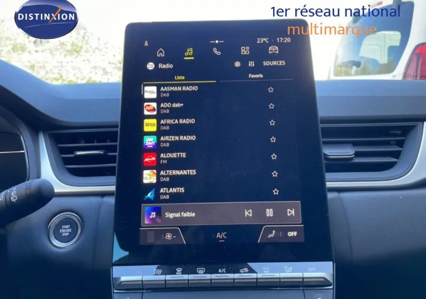 Vue intérieure centrée sur l'écran tactile multimédia du Renault Captur E-Tech noir, avec commandes de climatisation visibles.