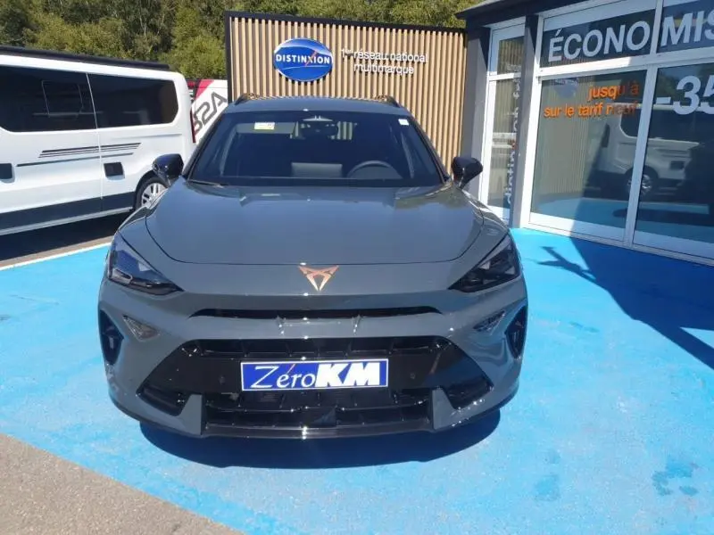 Vue avant d'une CUPRA Formentor bleu Fjord avec logo cuivré et calandre noire brillante sur parking bleu.
