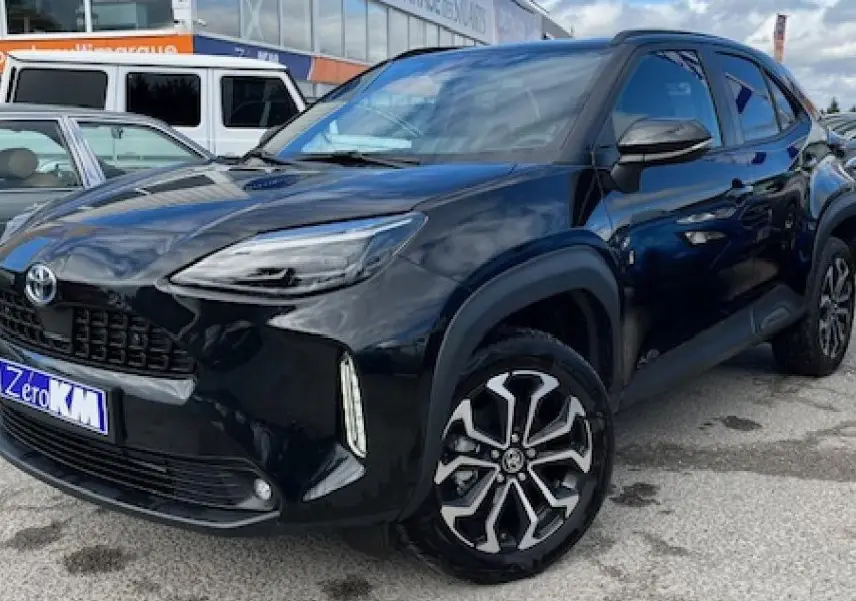 Toyota Yaris Cross 130H Design 2025 noir vue 3/4 avant droit en showroom avec jantes alliage distinctives