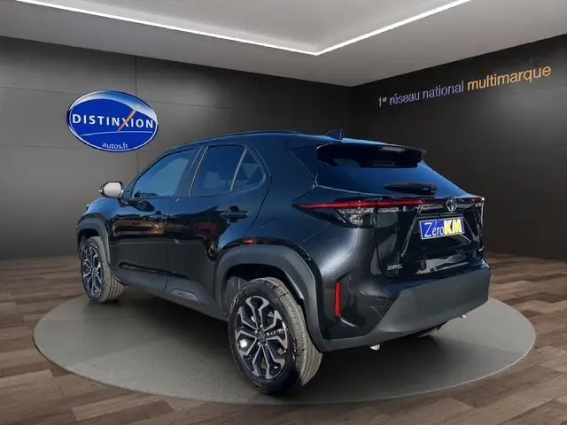 Vue 3/4 arrière droite d'une Toyota Yaris Cross 130H Design noire 2025 en hybride essence avec jantes alliage distinctives.