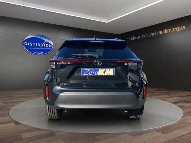 Vue arrière d'une Toyota Yaris Cross 130H Design 2025 noire, hybride essence, en showroom avec logo Distinxion.