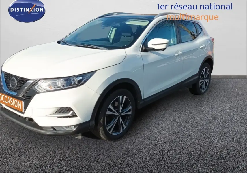 Nissan Qashqai blanc en 3/4 avant droit, avec jantes alliage bicolores et calandre distinctive noire.