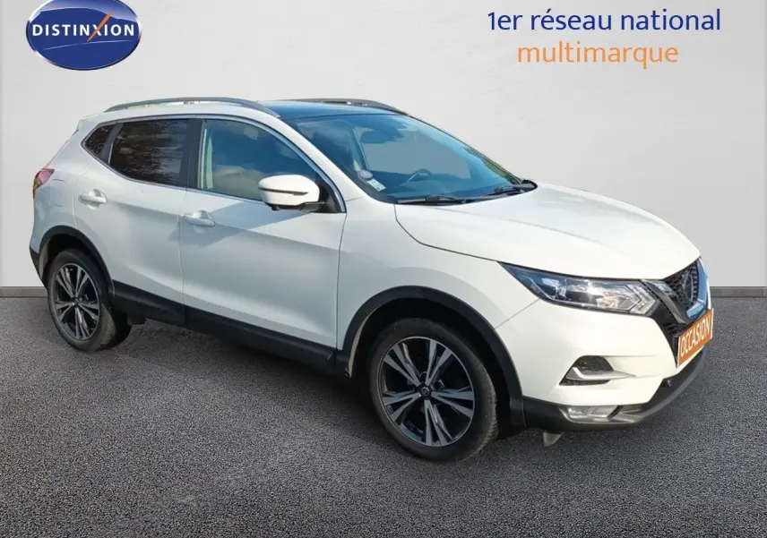 Nissan Qashqai blanc en 3/4 avant droit, avec jantes alliage bicolores et vitres teintées.