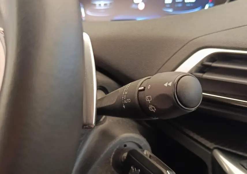 Gros plan sur la commande d’essuie-glace côté gauche du volant dans l’habitacle du Peugeot 5008 gris foncé.