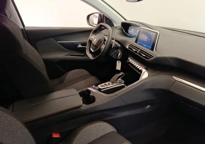 Intérieur de la Peugeot 5008 gris foncé, vue côté conducteur, tableau de bord avec écran tactile et volant multifonctions.