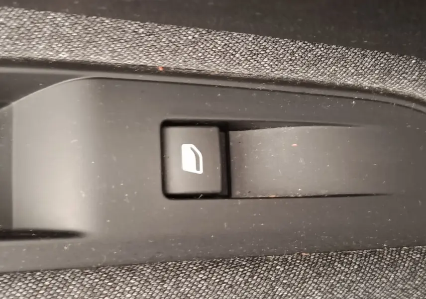 Gros plan sur le bouton de verrouillage des portes dans l'habitacle du Peugeot 5008 gris foncé.