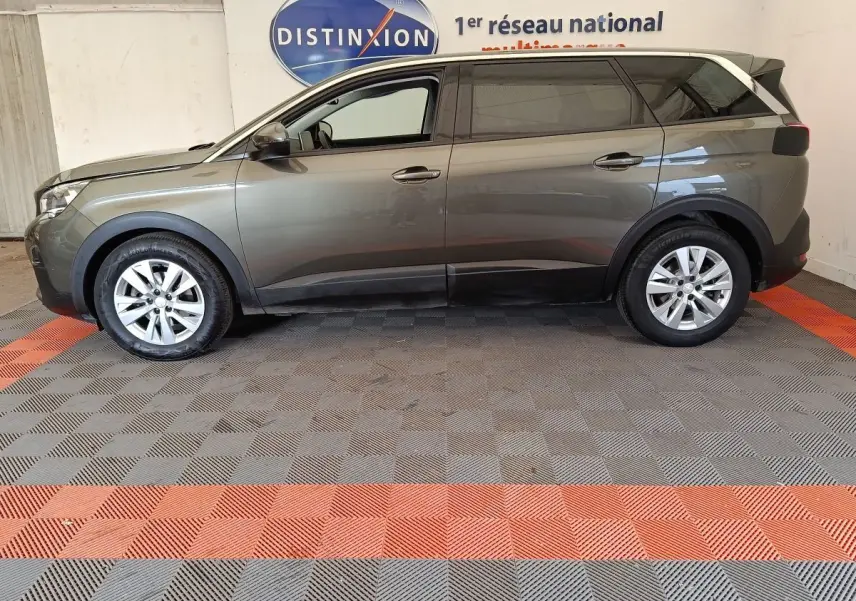 Peugeot 5008 gris foncé vue de profil côté gauche, SUV 7 places avec jantes alliage et toit noir.